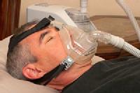 En la imagen se puede ver a un paciente que sufre apnea del sueño, que lleva colocada una CPAP, una mascarilla que le suministra oxígeno a presión durante la noche para mantener sus vías aéreas abiertas,